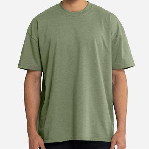 A person wearing an oversized short-sleeve crewneck t-shirt in sage green, shown from the neck down against a light gray background. Custom over size shirt print Next Level 7200