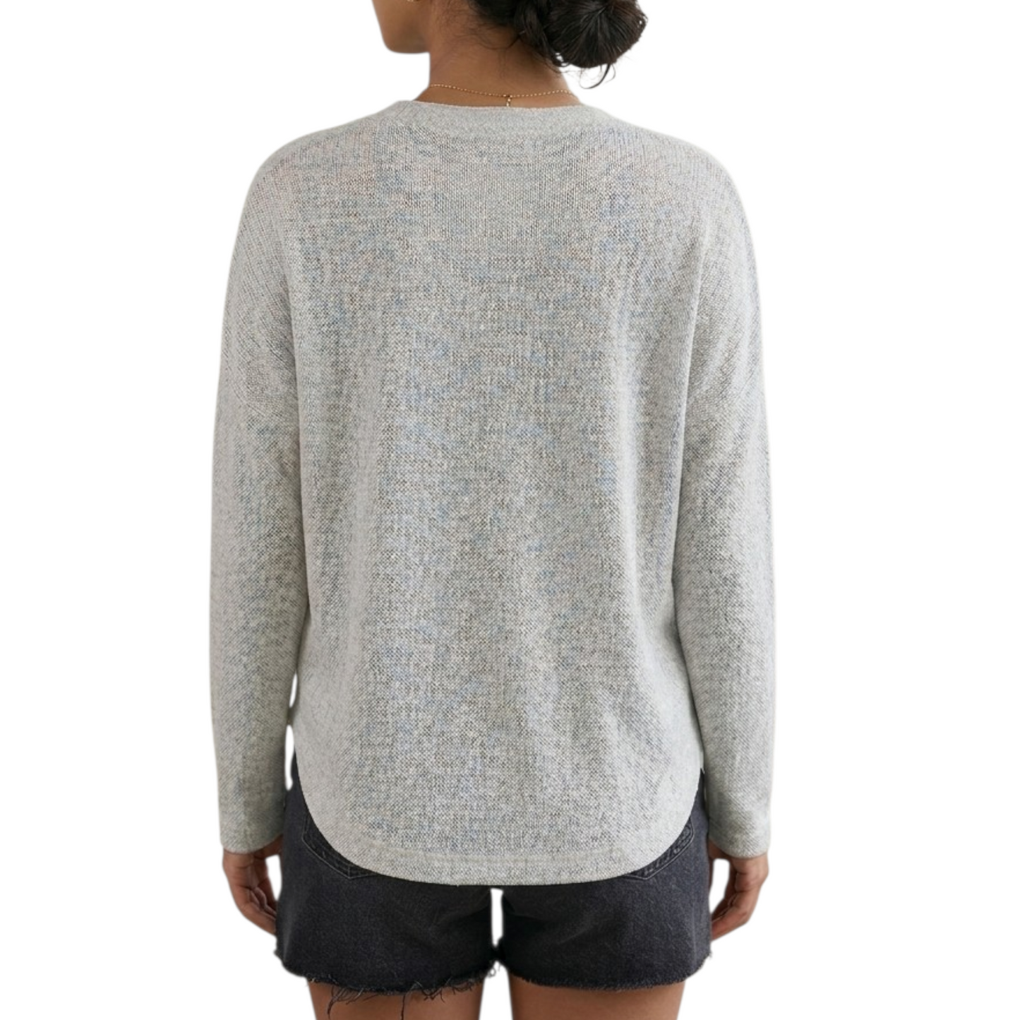 Person wearing a light gray sweater and dark shorts on a white background