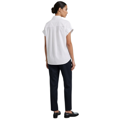 Woman wearing a white blouse and black pants on a white background