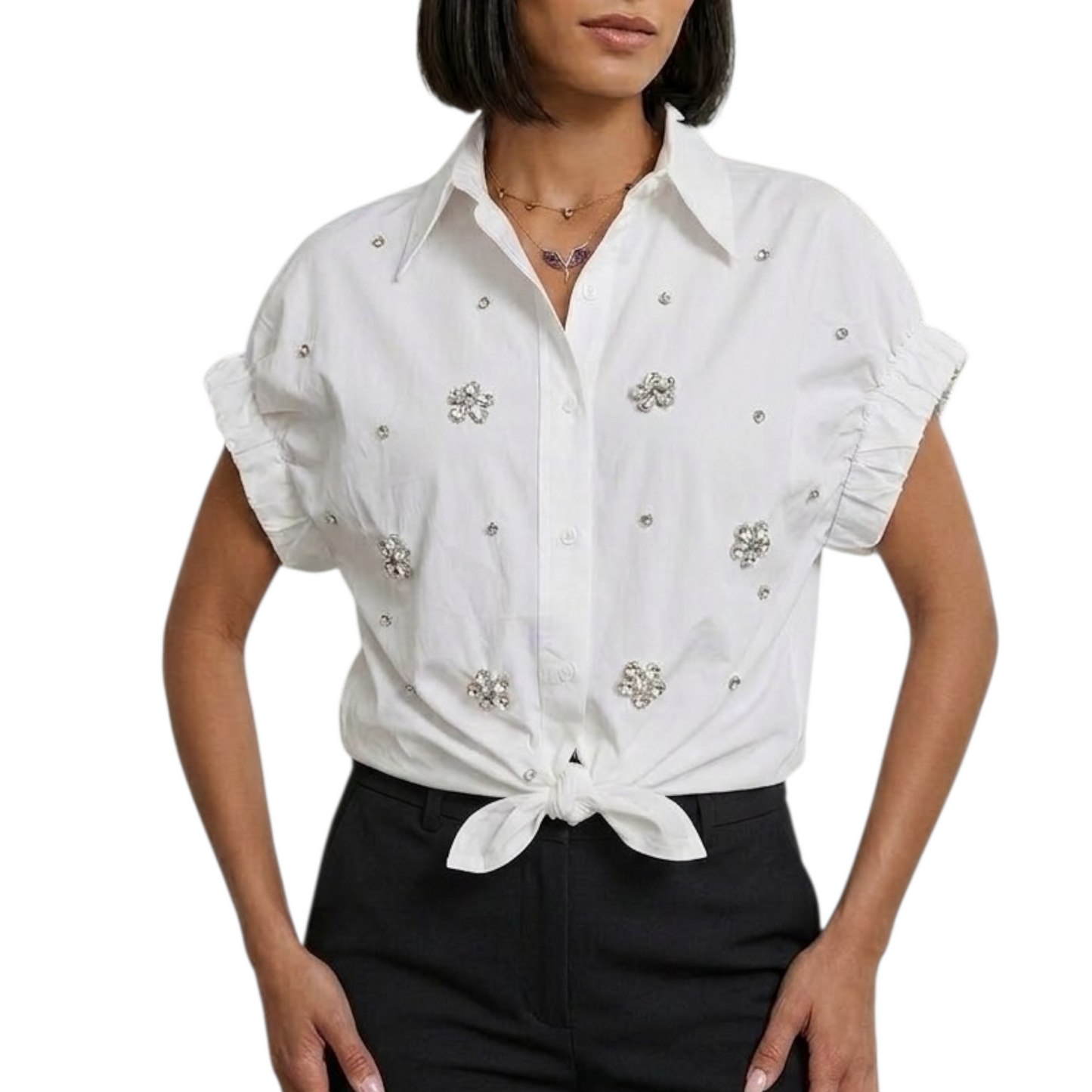 White blouse with decorative embellishments worn by a person on a white background